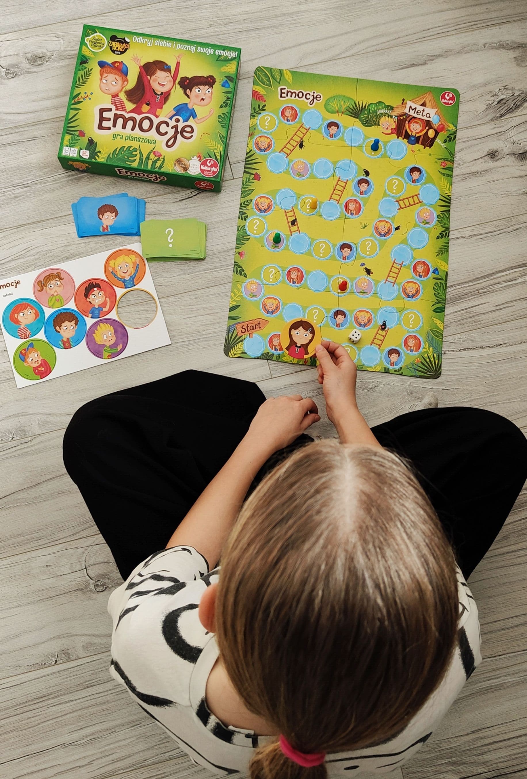 Dziewczynka gra w grę Emocje na terapii psychologicznej